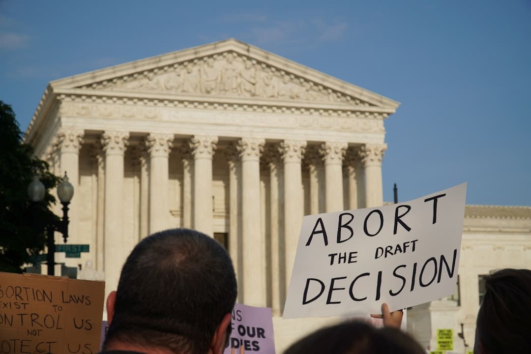 FHA ADA conflict. A group of people in front of a white building with columns with United States Supreme Court Building in the background