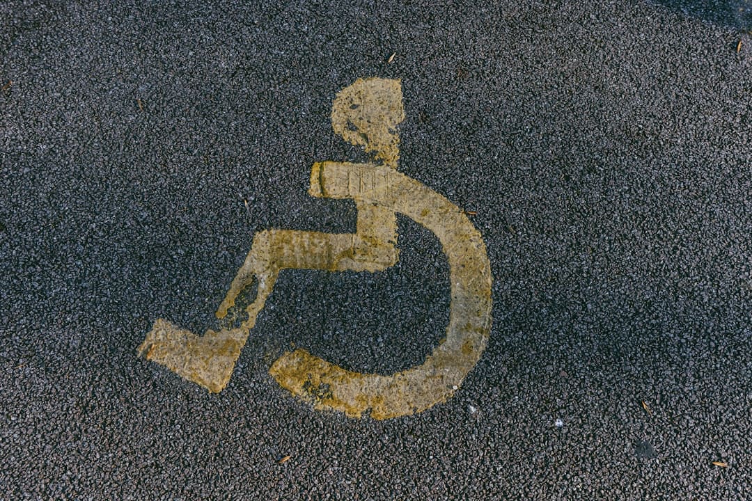 DOJ enforcement ADA — a handicapped sign is painted on the pavement