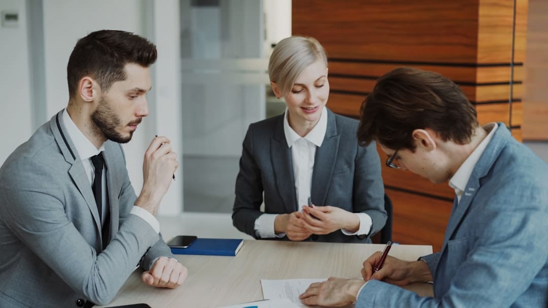 multiple support animals — Business people signing a contract at a table.